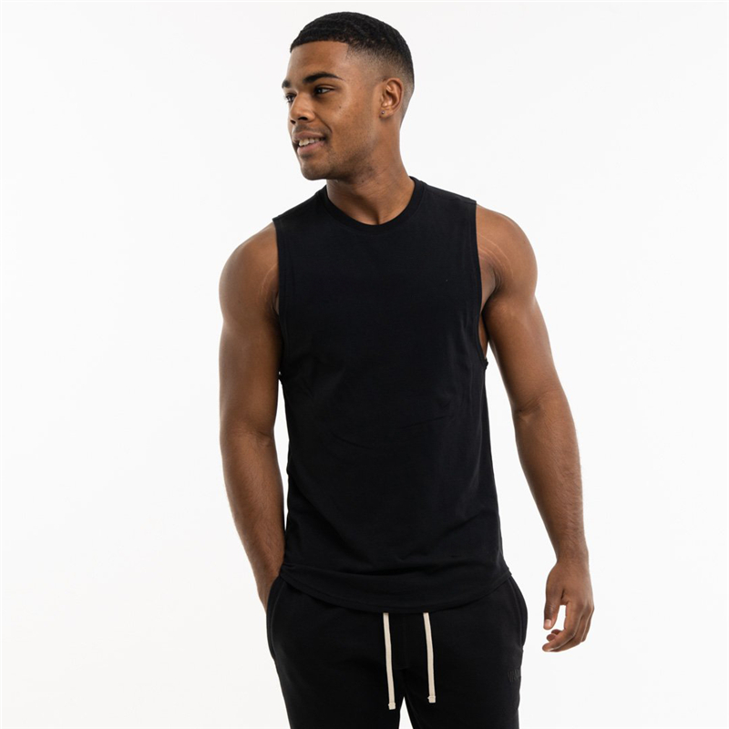 Stylish man wearing a loose sleeveless black cotton tank top, perfect for alternative gym style.