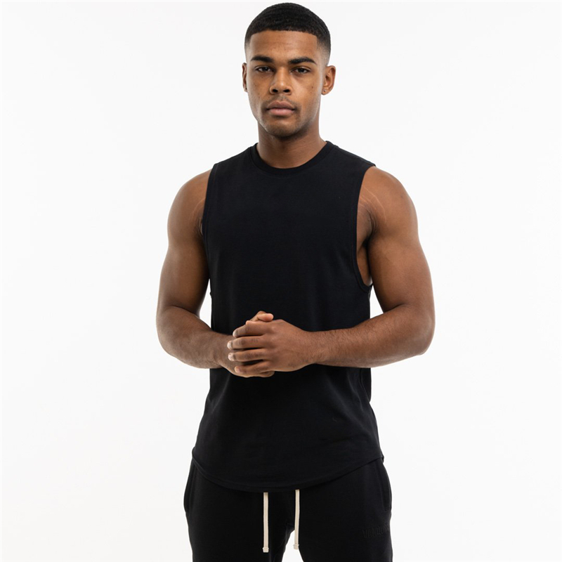 Man wearing a black sleeveless cotton tank top, showcasing a trendy alternative style for gym clothing.