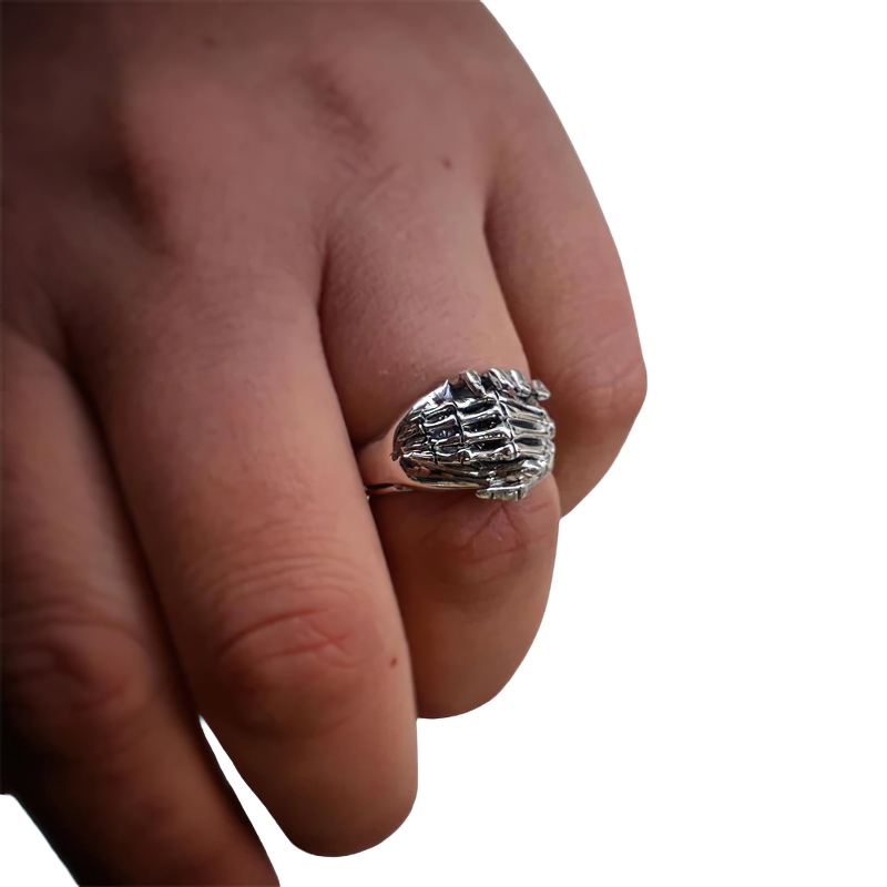 Skeleton hands puzzle ring on a finger, showcasing stylish unisex stainless steel jewelry for couples.