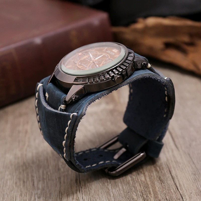 Stylish men's luxury quartz watch with big dial and blue leather strap on wooden surface.