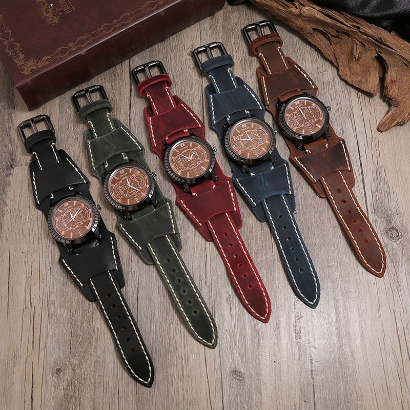 Collection of luxury big dial quartz men's watches with leather straps in various colors on wooden background.