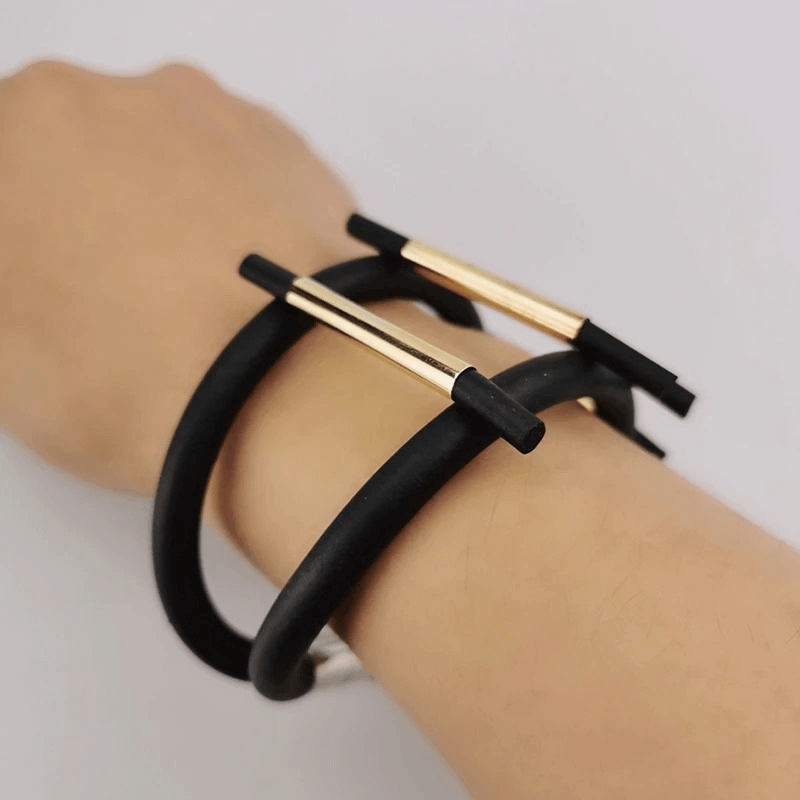 Luxury black rubber charm bracelet with magnetic clasp on a model's wrist, perfect for punk style outfits.