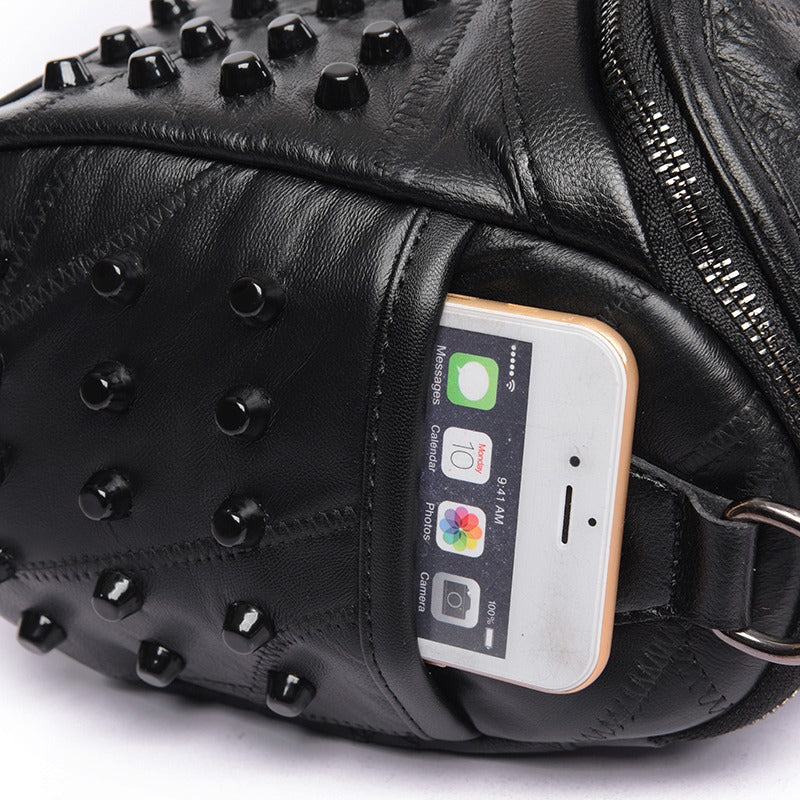 Close-up of a black women's sheepskin bag featuring rivets and a smartphone in the pocket, blending style and convenience.