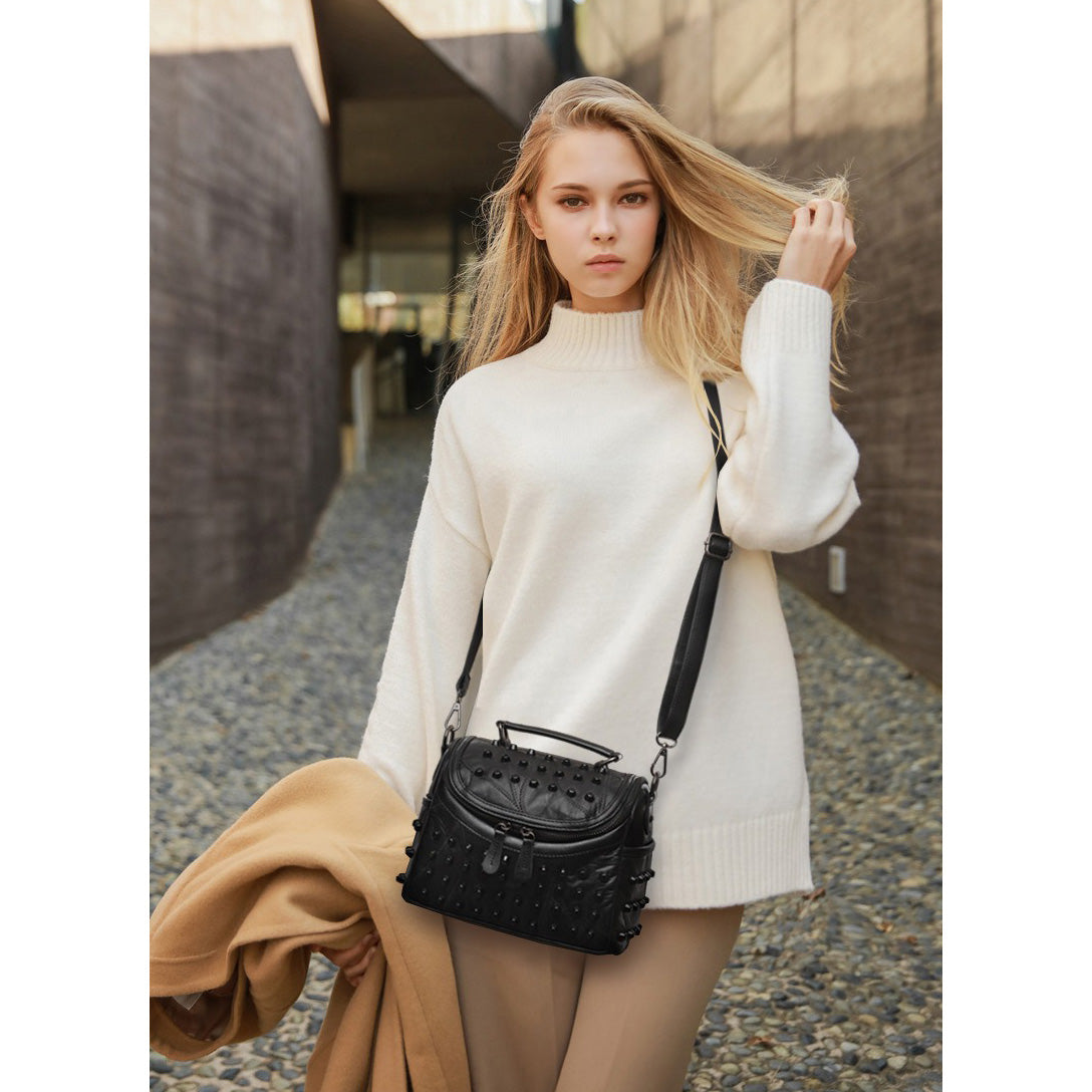 Stylish woman in a white sweater carrying a luxury black women's sheepskin messenger bag.