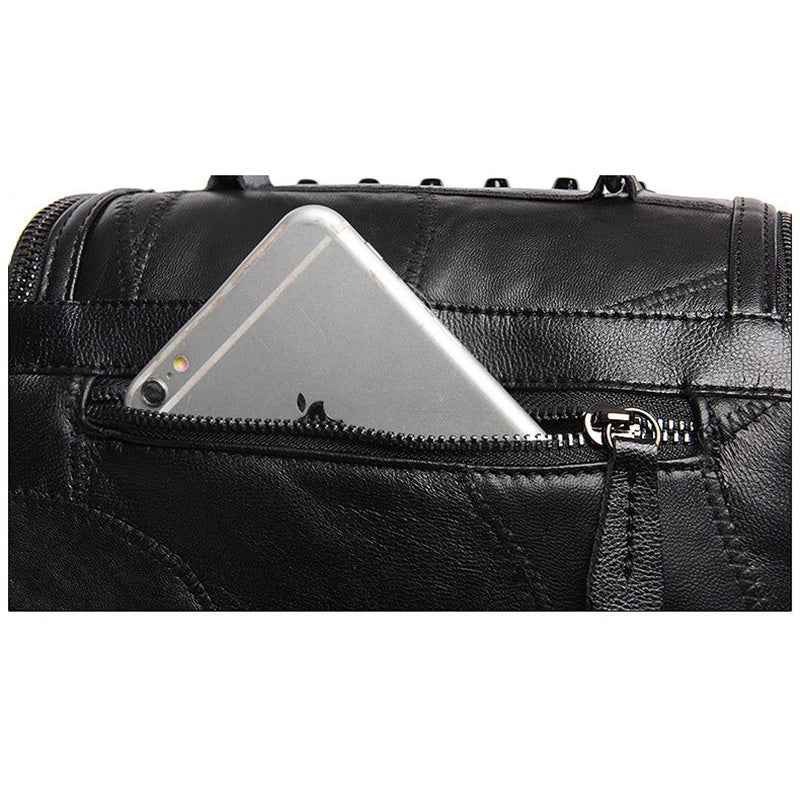 Close-up of a luxury black women's sheepskin bag with a smartphone tucked into a zippered pocket.