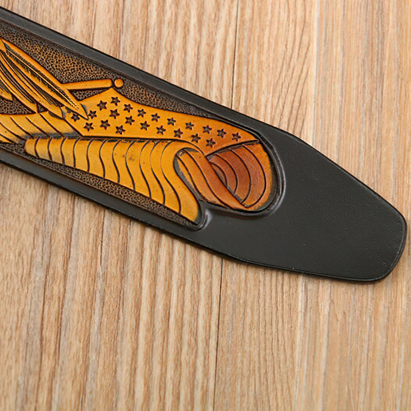 Luxury genuine leather belt for men featuring intricate eagle print design on a wooden background.