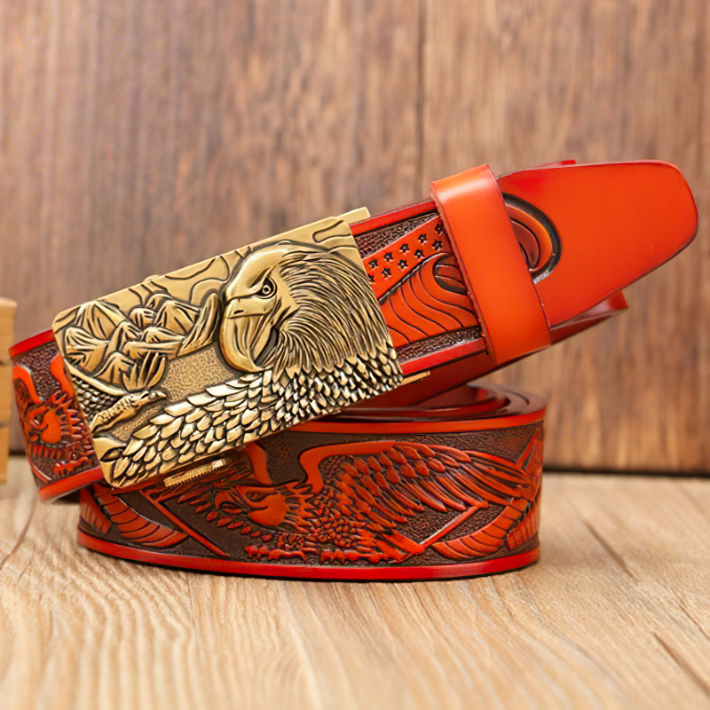 Luxury men's leather belt featuring detailed eagle print and bold buckle on a wooden background.