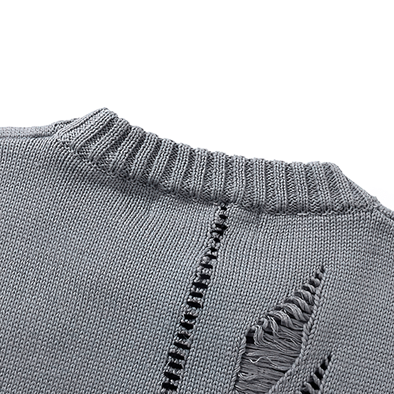 Close-up of the luxurious oversized gray sweater with unique distressed graffiti detailing on the fabric.