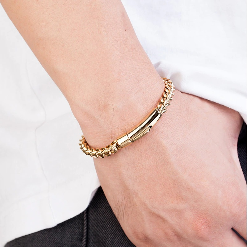 Luxury gold stainless steel chain bracelet for men in punk rock style worn on wrist.