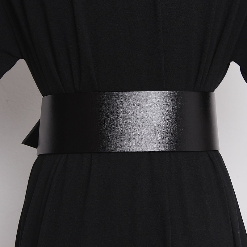 Wide black leather belt for women, featuring a sleek metal buckle for stylish outfits.