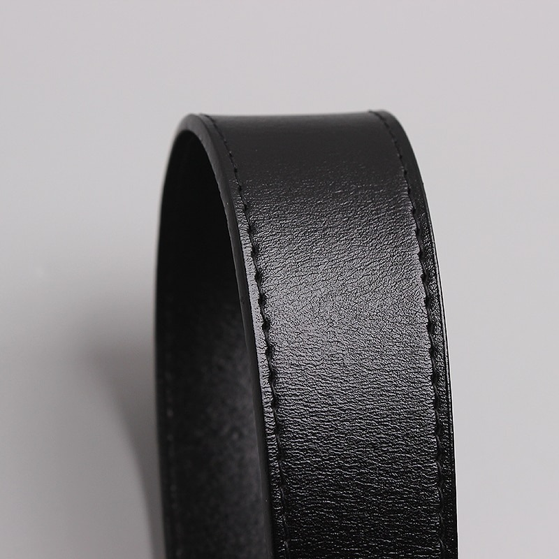 Close-up of a luxurious wide black leather belt showcasing its smooth texture and craftsmanship.