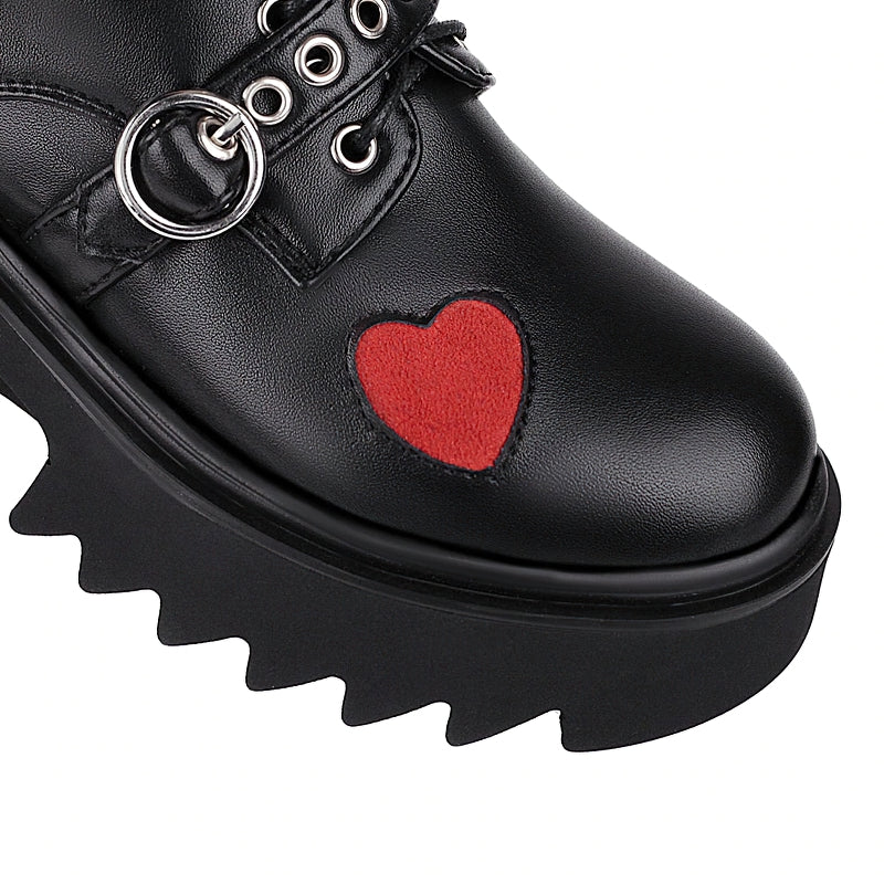 Close-up of women's gothic chunky pumps with red heart detail and black platform sole, perfect for punk fashion.