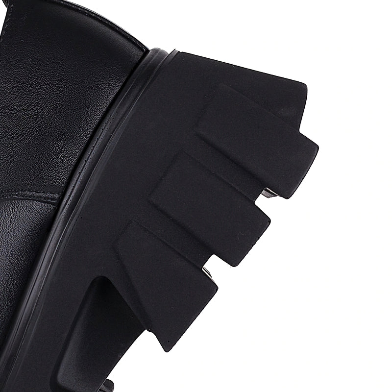 Close-up of the chunky black heel of luxury women's gothic pumps with distinctive serrated design.