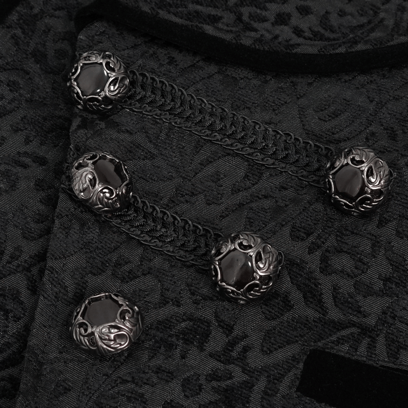 Close-up of patterned metal buttons and jacquard fabric on a men's black waistcoat, showcasing gothic style.