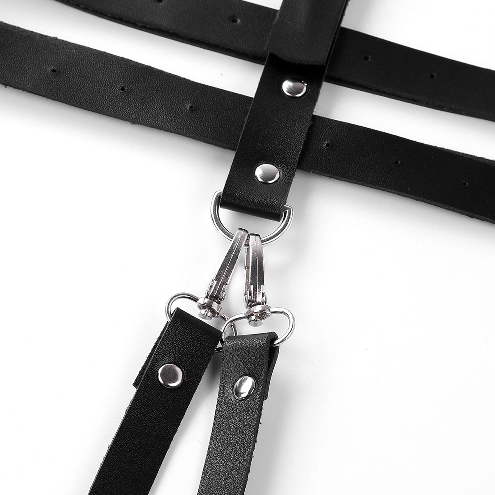 Close-up of a black faux leather body harness with silver o-rings and rivets, showcasing gothic design details.
