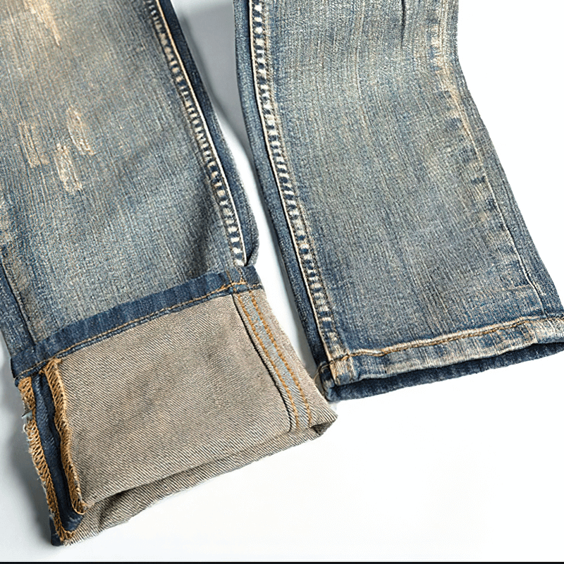 Close-up of ripped male embroidery denim jeans showcasing stylish fabric details and trendy cut for alternative clothing.