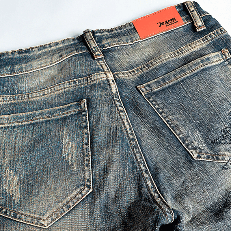 Back view of trendy male embroidery denim jeans, showcasing stylish ripped design and alternative fashion.