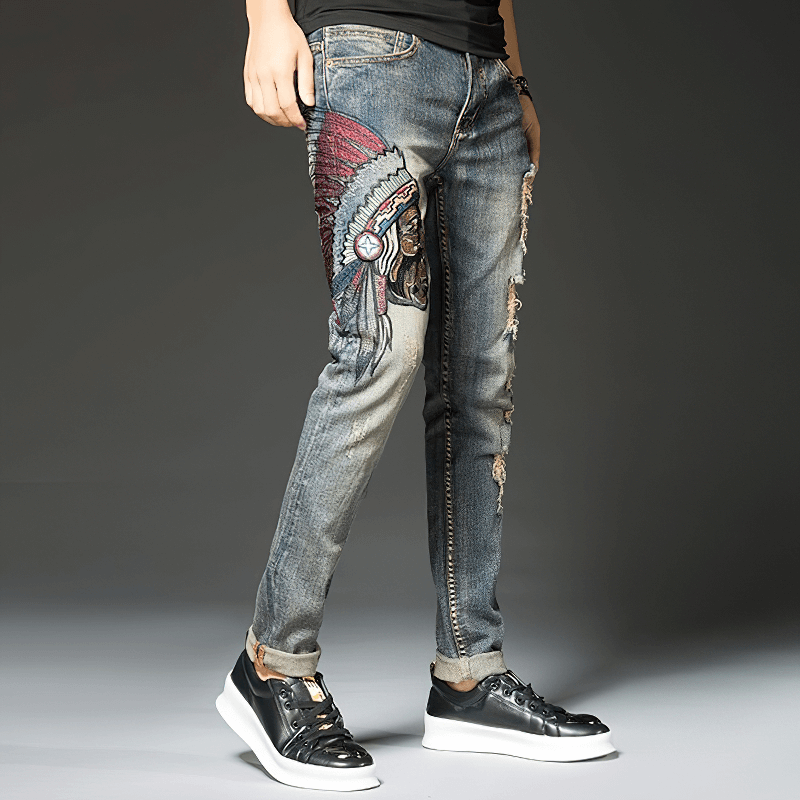 Stylish male wearing ripped denim jeans with trendy embroidery, showcasing alternative fashion for men.
