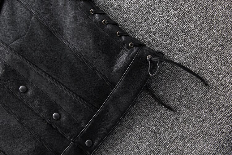 Close-up of a sleek black genuine leather motorcycle vest with laces on sides, perfect for bikers.