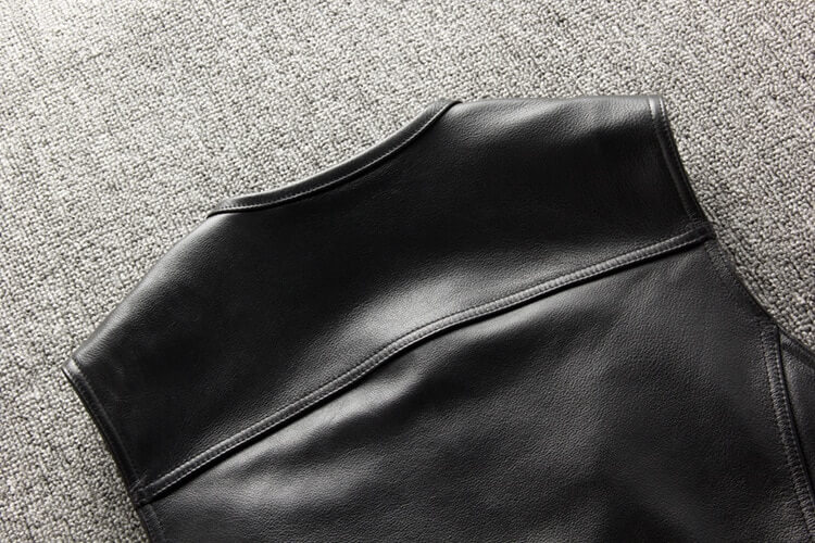 Close-up of a sleek black genuine leather motorcycle vest showcasing quality craftsmanship.