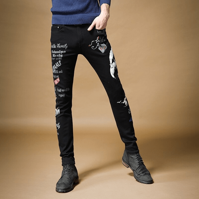 Men's black denim graffiti print pants in slim fit, showcasing unique designs for an alternative style.
