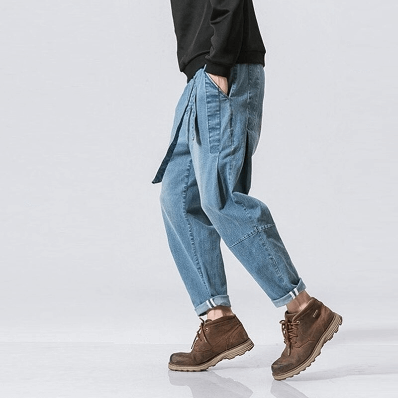 Men's loose denim pants with belt in casual style, perfect for comfort and trendy outfits.