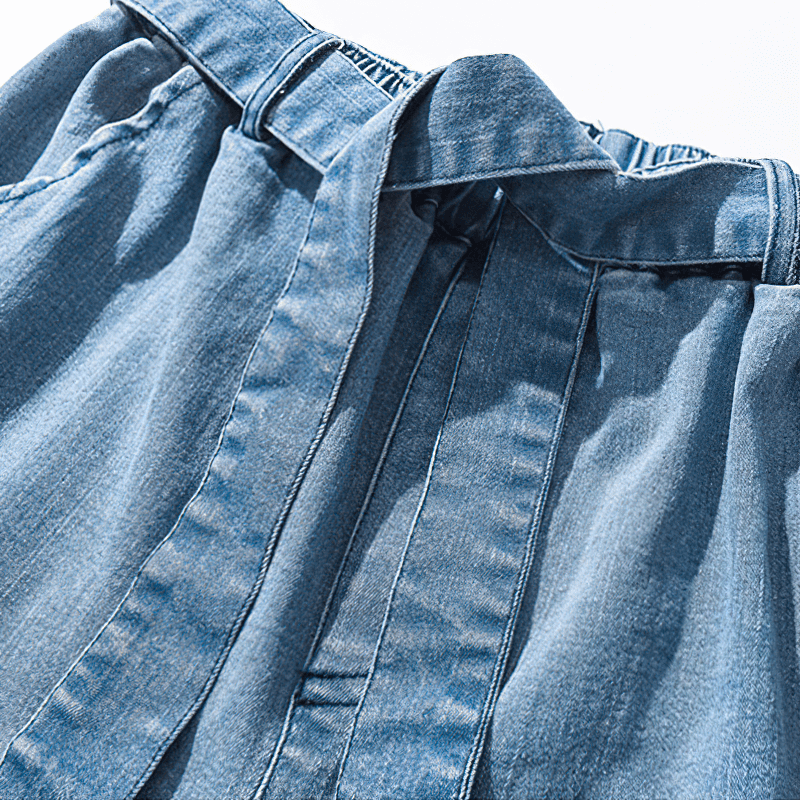 Close-up of the waistband and belt of stylish loose denim pants for men in casual style.