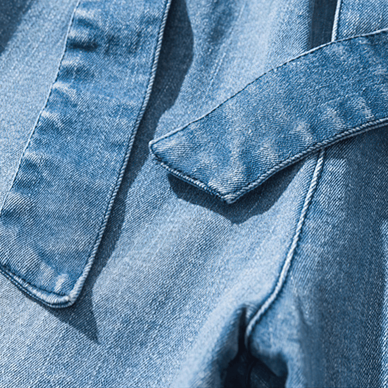 Close-up of men's loose denim pants belt detail in stylish casual design.