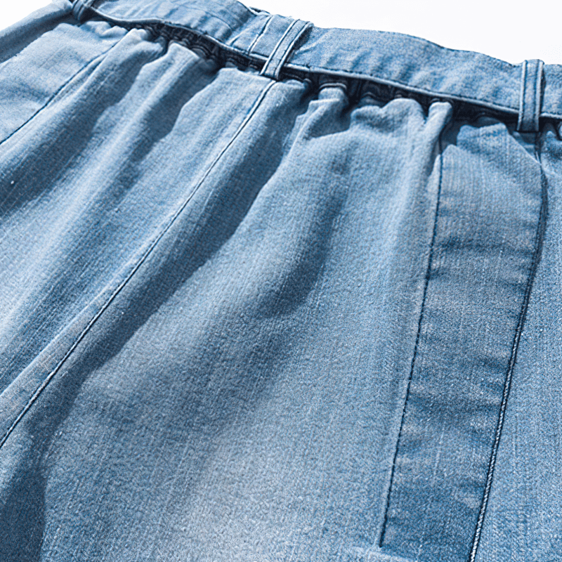 Close-up of the waistband and fabric of loose denim pants, showcasing casual and stylish design.
