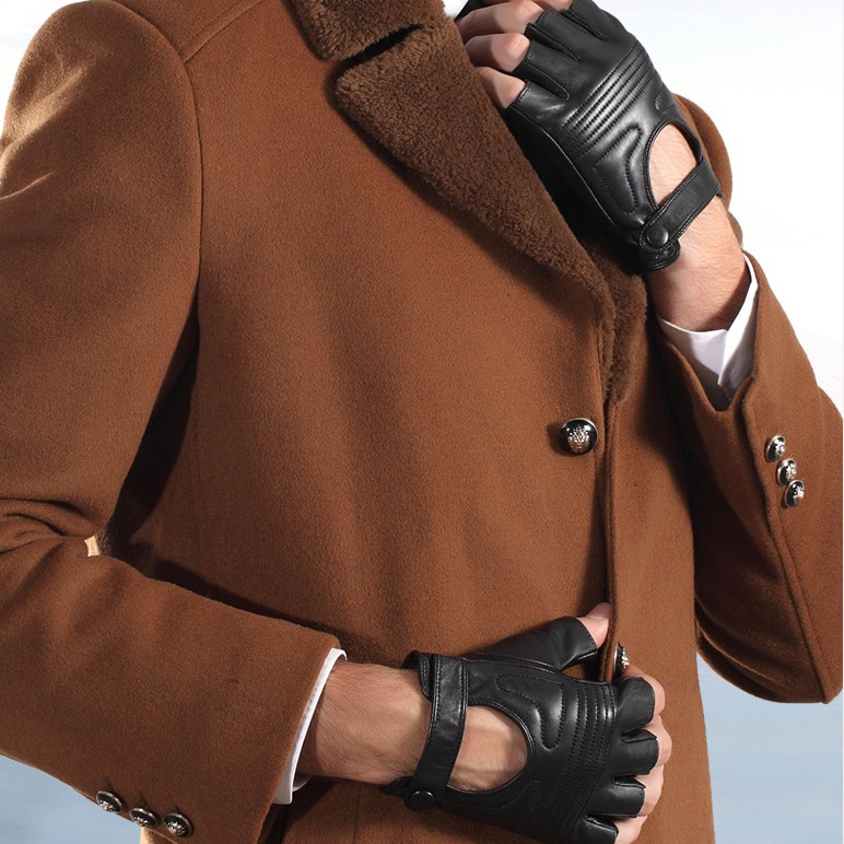 Stylish man wearing black fingerless leather gloves with a brown coat in a chic punk style.