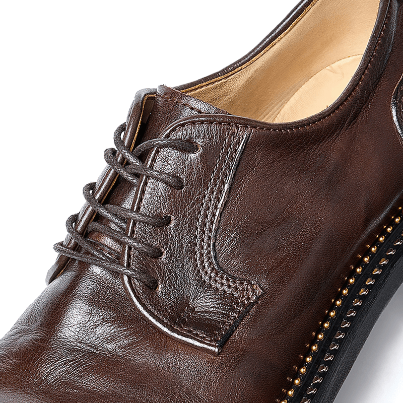 Close-up of elegant brown leather Oxford shoes with laces and classic detailing for men.