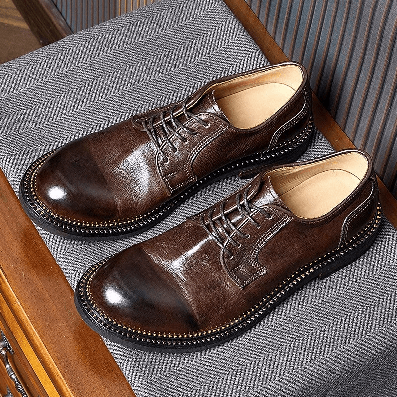 Elegant men's retro leather Oxford shoes in rich brown, showcasing soft lace-up design on stylish fabric background.