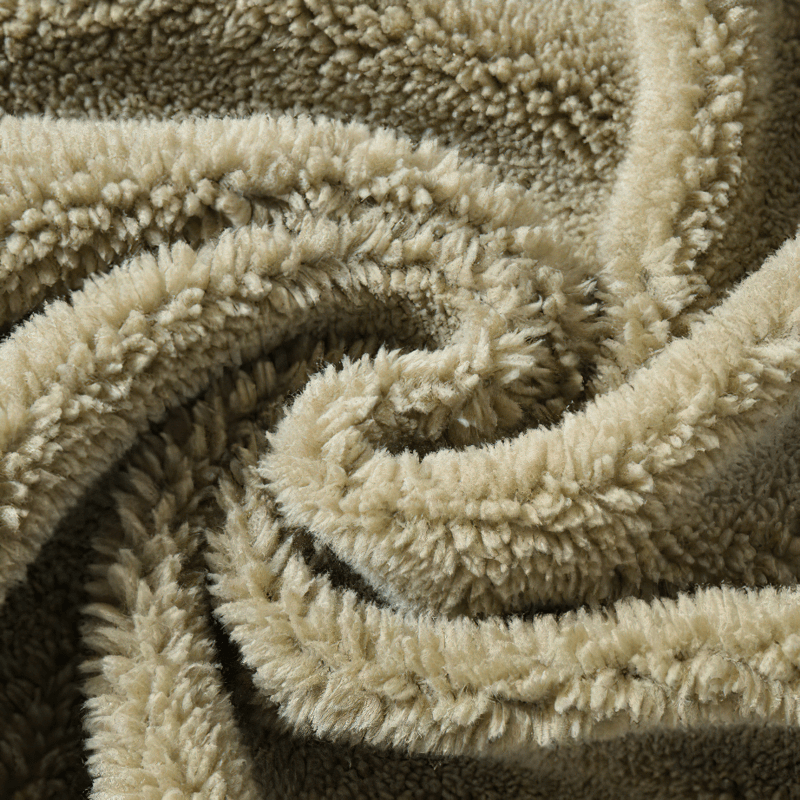 Cozy texture of a soft, plush beige fleece blanket, perfect for warmth and comfort.