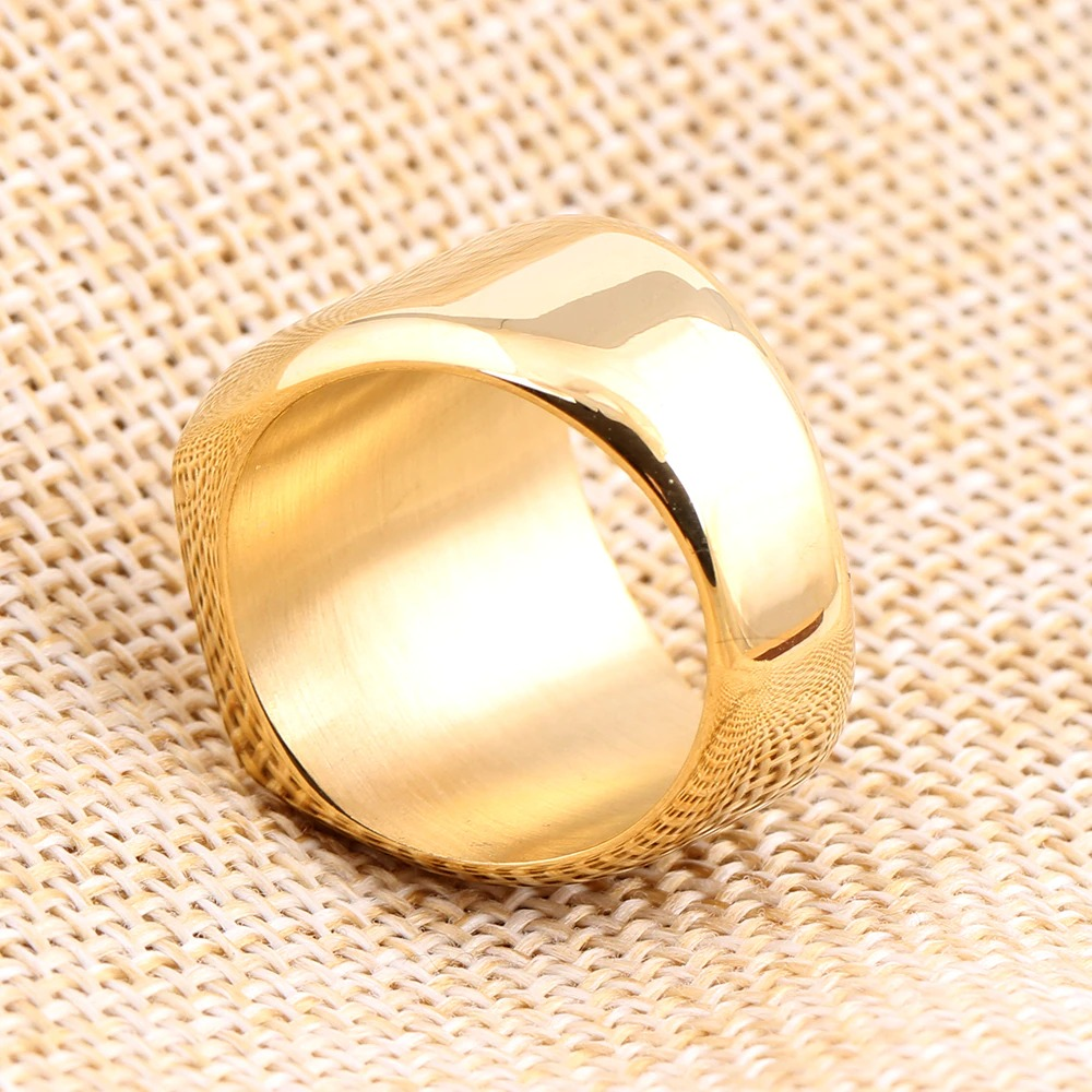 Stylish gold Masonic signet ring for men and women on a textured fabric background, showcasing unique geometric design.