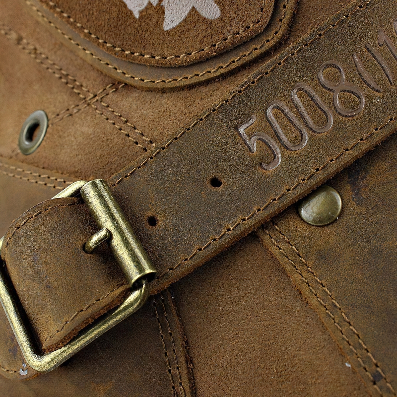 Close-up of a stylish brown leather boot with a buckle and embossed strap detail, perfect for casual rock fashion.