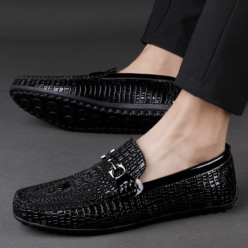 Black leather loafers with textured pattern and stylish buckle, perfect for modern gothic fashion.