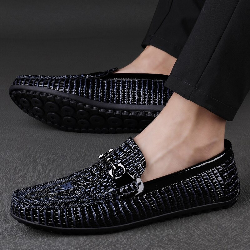 Black leather loafers with textured design and buckle, perfect for versatile stylish outfits.