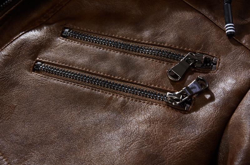 Close-up of zippers on a brown synthetic leather motorcycle jacket, showcasing stylish details and quality craftsmanship.
