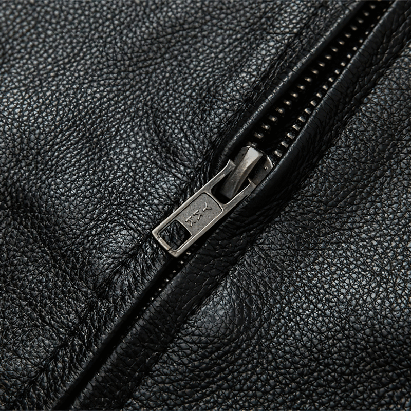 Close-up of the zipper on a men's black genuine leather motorcycle jacket, showcasing quality craftsmanship.