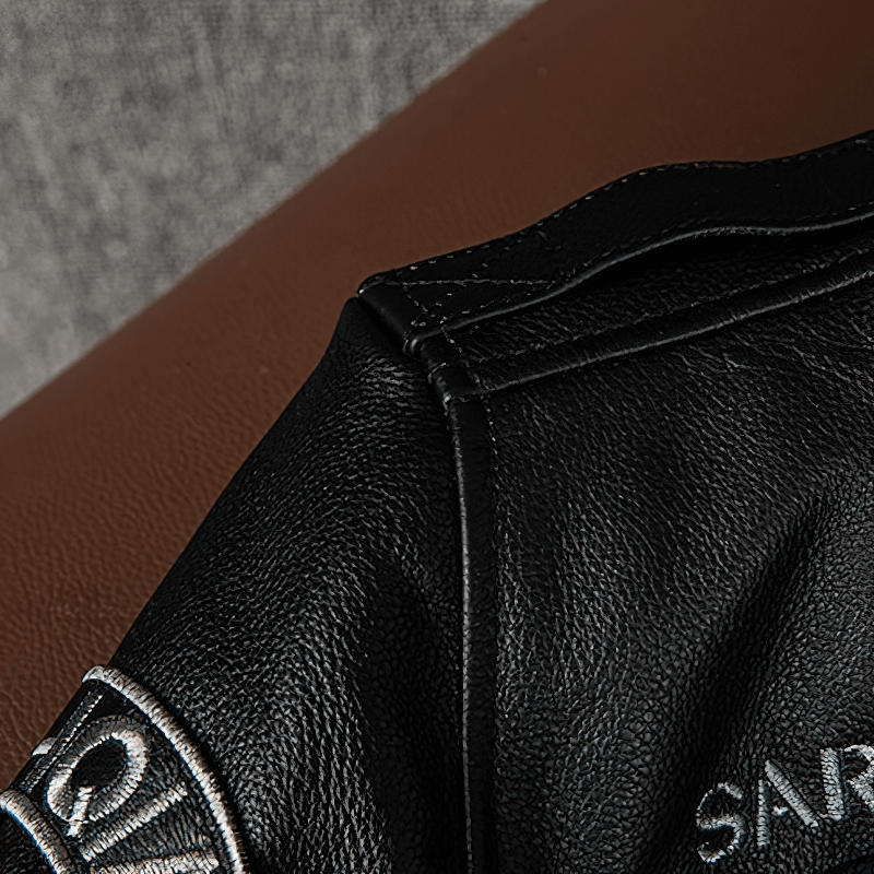 Close-up of a men's genuine leather motorcycle jacket with embroidery and detailed stitching.