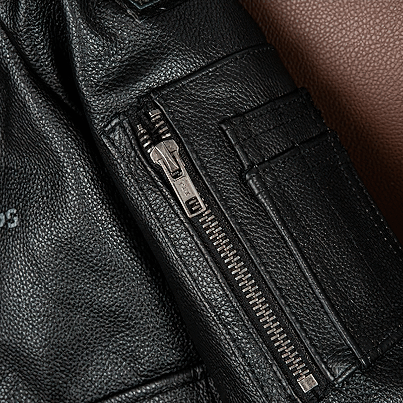 Close-up of a black genuine leather motorcycle jacket showcasing zippers and pockets for functional style.