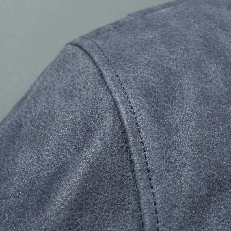 Close-up of the texture and stitching on a men's genuine leather motorcycle jacket in a blue shade.