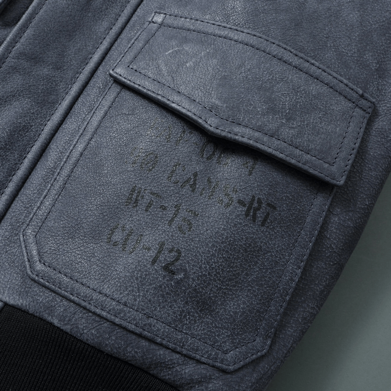 Close-up of a men's genuine leather motorcycle jacket pocket with textured fabric and embossed details.