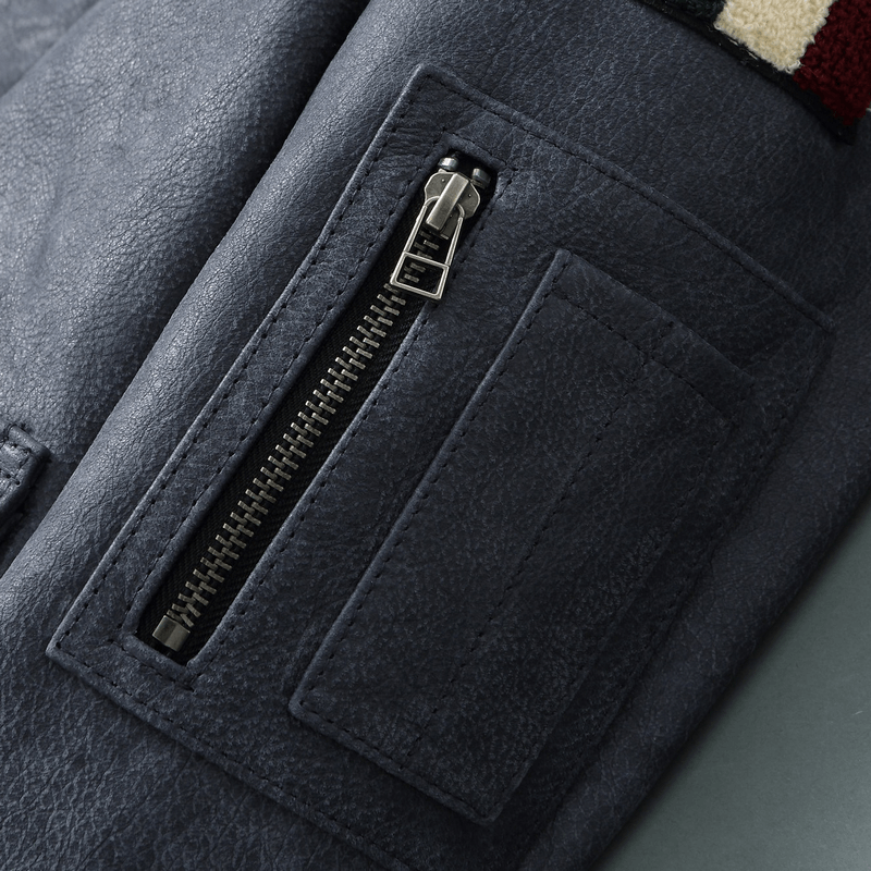 Close-up of a men's genuine leather motorcycle jacket sleeve featuring a stylish zipper pocket.