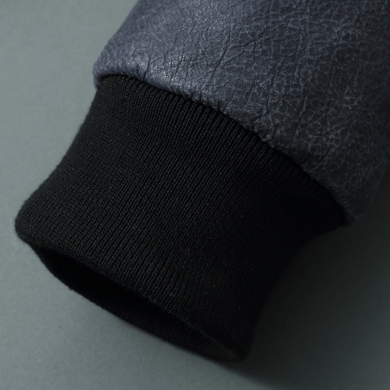 Close-up of men's leather jacket sleeve showing textured fabric and ribbed cuff.