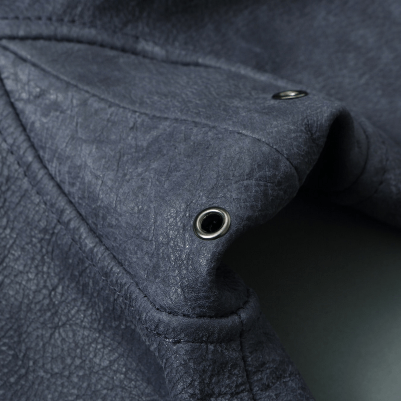 Close-up of textured genuine leather in a men’s motorcycle jacket showcasing detailed craftsmanship and eyelets.