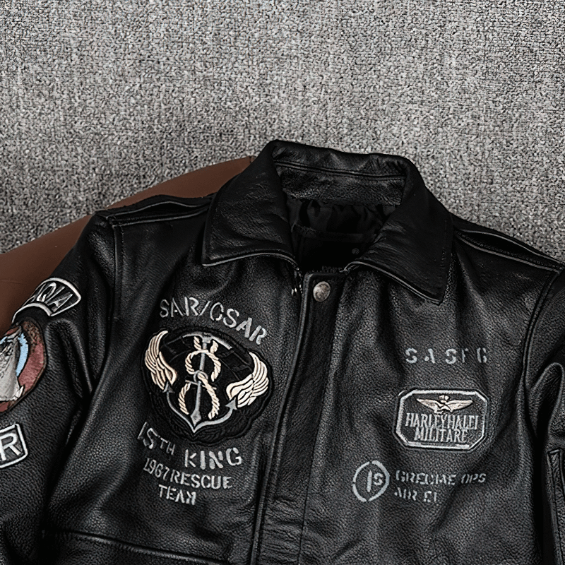 Men's black genuine leather motorcycle jacket with embroidered patches and detailed design.