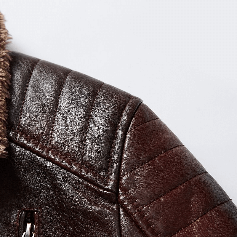 Close-up of the brown leather shoulder of a men's fur collar jacket, showcasing quilted details and luxurious texture.