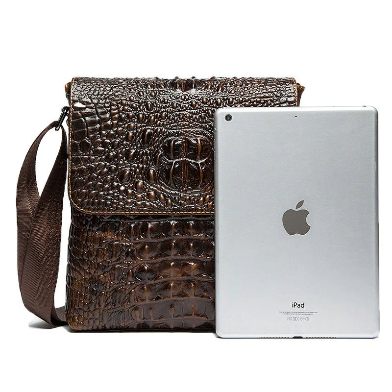 Men's genuine leather bag with crocodile pattern next to an iPad, showcasing a stylish shoulder flap design.