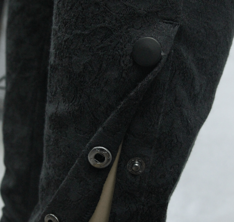 Close-up of men's goth baggy trousers with delicate black patterned fabric and stylish button details.